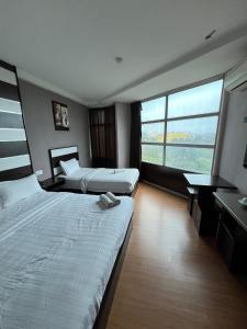 Pokój hotelowy z 2 łóżkami i biurkiem w obiekcie Hotel Economy Kapar w mieście Kapar