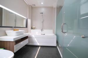 a bathroom with a white tub and a sink and a shower at Mother's Home in Ho Chi Minh City