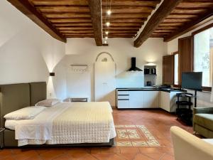 a bedroom with a white bed and a kitchen at Regis Condo in Siena