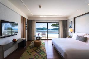 a hotel room with a bed and a view of the ocean at The Nai Harn in Nai Harn Beach +49 photos