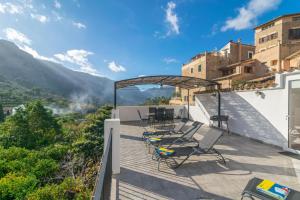 a balcony with chairs and a view of the mountains at Cas Decu in Fornalutx