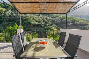 a table with a bowl of fruit on top of a balcony at Cas Decu in Fornalutx