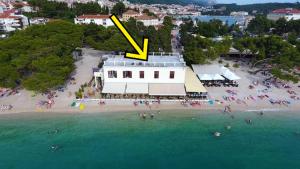 a yellow arrow pointing to a building on a beach at Beach rooms Riviera - Žuta Kuća in Makarska