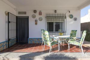 une terrasse avec une table et des chaises dans une maison dans l'établissement Dulce Carmen, à Bonanza