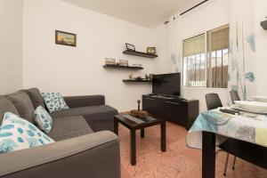 een woonkamer met een bank en een tv bij Dulce Carmen in Bonanza