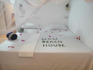 ein Bett mit einem Schild, auf dem "Wünsch-französisches Haus" steht in der Unterkunft Wow Beach House in Jambiani