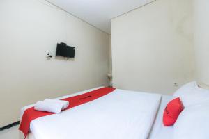 Letto o letti in una camera di RedDoorz at Osuko Residence Sukomanunggal Jaya