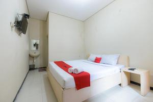 Letto o letti in una camera di RedDoorz at Osuko Residence Sukomanunggal Jaya