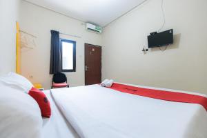 Letto o letti in una camera di RedDoorz at Osuko Residence Sukomanunggal Jaya