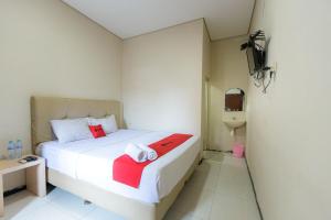 Letto o letti in una camera di RedDoorz at Osuko Residence Sukomanunggal Jaya
