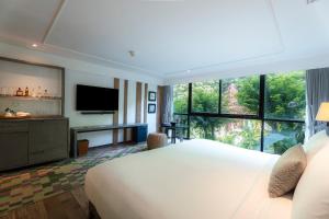 a bedroom with a large bed and a large window at The Nai Harn in Nai Harn Beach
