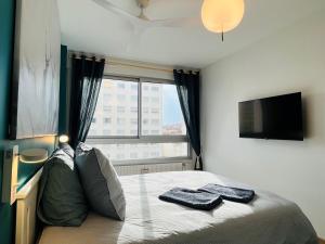 a bedroom with a bed with a tv and a window at Central, confort, 2 chambres, parking - Lyon 6e in Lyon