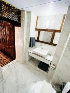 ein weißes Badezimmer mit einem Waschbecken und einem Spiegel in der Unterkunft Dostlar Konagi in Şahinbey