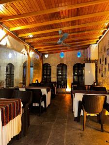 un restaurante con mesas y sillas en una habitación en Dostlar Konagi en Şahinbey