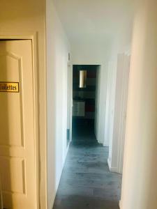 an empty hallway with a door with a sign on it at Booking in Clichy