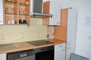 a kitchen with white cabinets and a stove top oven at Monteur-Bungalow Dortmund in Dortmund