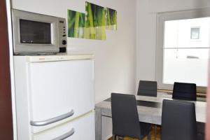a kitchen with a table with chairs and a microwave at Monteur-Bungalow Dortmund in Dortmund