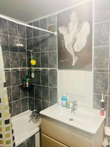 een badkamer met een wastafel en een spiegel bij Booking in Clichy