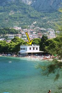 ein Gebäude an einem Strand mit einem x drauf in der Unterkunft Beach rooms Riviera - Žuta Kuća in Makarska