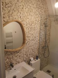 a bathroom with a toilet and a sink and a mirror at Villa Sérénité in Noisy-le-Grand