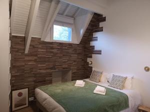 a bedroom with a large bed and a brick wall at Villa Sérénité in Noisy-le-Grand