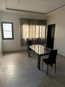 a dining room with a glass table and chairs at Keeluxe Cite Keur Gorgui- Superbe appartement in Dakar