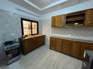 a large kitchen with wooden cabinets and a stove at Keeluxe Cite Keur Gorgui- Superbe appartement in Dakar