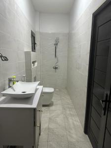 a bathroom with a toilet and a sink and a shower at Keeluxe Cite Keur Gorgui- Superbe appartement in Dakar
