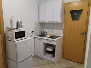 a small kitchen with a microwave and a refrigerator at Prenoćište Skitnica Kapronca in Koprivnica