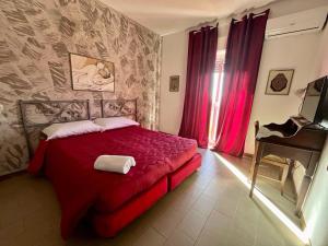 a bedroom with a red bed and a piano at Ares Hotel in San Giovanni la Punta