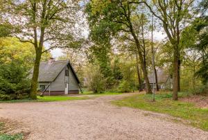 a dirt road leading to a house and trees at Summio Bungalowpark Herperduin in Herpen