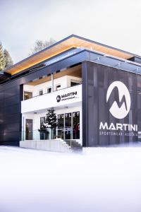 un bâtiment avec un panneau de moelle devant lui dans l'établissement ALPINE LOFT Martini, à Annaberg-Lungötz