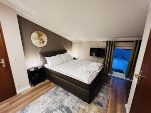 1 dormitorio con 1 cama y reloj en la pared en Hotel Garni BALTICpetite, en Heringsdorf