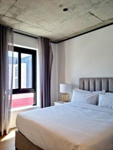 Un dormitorio con una cama grande y una ventana en 9 Palms by Smart City Stays, en Ciudad del Cabo