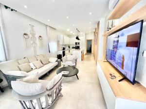 Una sala de estar con un sofá y un televisor. en Crystal-Blue-Villa Protaras, en Protaras