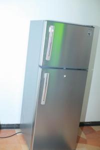 un frigorifero in acciaio inossidabile con un adesivo verde di Yino Villa a Midigama East