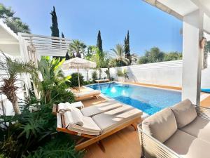 un patio con piscina y sillas y una piscina en Crystal-Blue-Villa Protaras, en Protaras
