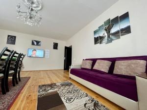 a living room with a purple couch and a dining room at AkbA-Frame2 in İsmayıllı