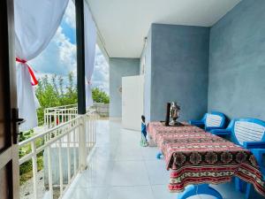 een kamer met een tafel en stoelen en een balkon bij AkbA-Frame2 in İsmayıllı