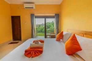 una camera da letto con un grande letto con cuscini arancioni di Srinadi Waterpark Villa a Klungkung