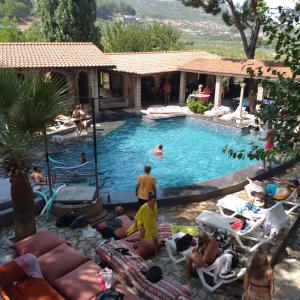 um grupo de pessoas sentadas ao redor de uma piscina em Efes Hidden Garden Resort Otel em Selçuk