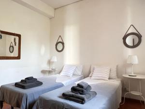 two beds in a white room with towels on them at Casa Bedda in Agnone Bagni