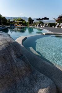 a large swimming pool with blue water and umbrellas at Paros Agnanti Resort & Spa in Parikia