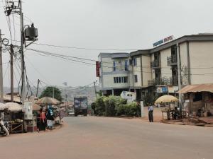 una strada vuota in una città con un edificio di TCHATCHA HOTEL a Yaoundé