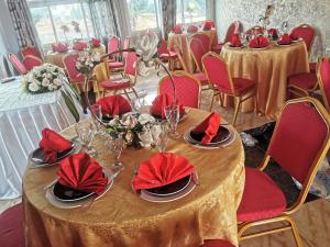 un comedor con mesas y sillas con servilletas rojas en TCHATCHA HOTEL, en Yaoundé