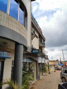 een gebouw waar een auto voor geparkeerd staat bij TCHATCHA HOTEL in Yaoundé