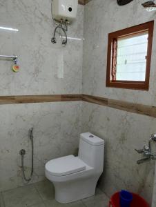 a bathroom with a toilet and a window at SR RESIDENCY in Chennai