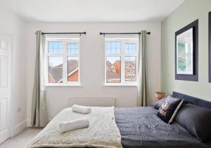 1 dormitorio con 1 cama y 2 ventanas en 4 Bedroom Apartment with non-smoking room, great location, free Wi-Fi & Parking - Big monthly price reduction en Lincolnshire