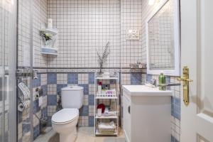 a bathroom with a white toilet and a sink at Villa Jacaranda in Cala del Moral +17 photos