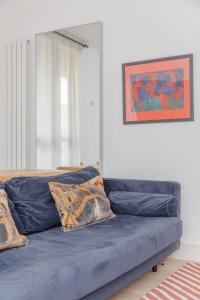 a blue couch in a living room with a painting at Charming & Stylish 1BD Flat - Bethnal Green in London